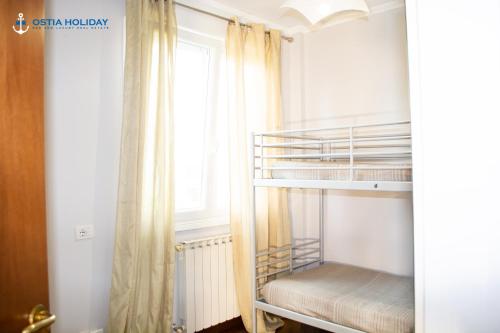 a bunk bed in a room with a window at Ostia Holiday Tancredi Chiaraluce in Lido di Ostia