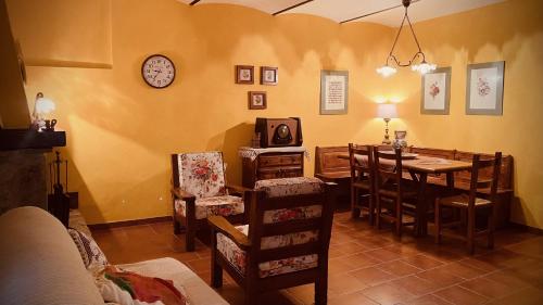 a dining room with a table and chairs and a clock at Casa vacanze Pian di Corte in Belmonte del Sannio