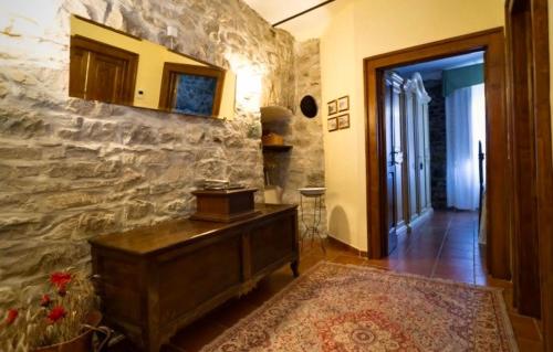 a hallway with a wooden dresser and a stone wall at Casa vacanze Pian di Corte in Belmonte del Sannio
