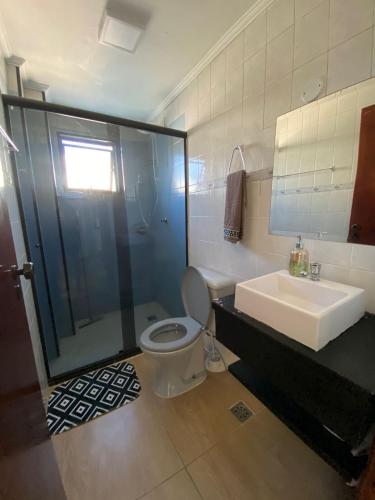 a bathroom with a shower and a toilet and a sink at Apartamento cidade ocian Praia Grande in Praia Grande