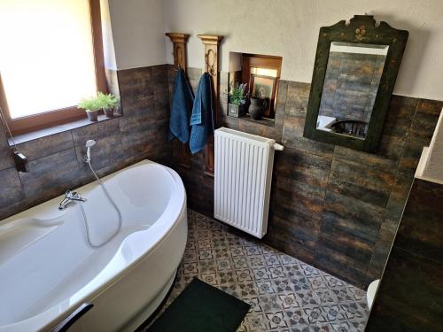 La salle de bains est pourvue d'une baignoire, d'un lavabo et d'un miroir. dans l'établissement Dom całoroczny JÓZEFINKA w Karkonoszach, à Kowary