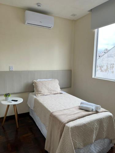a small bedroom with a bed and a window at Novo Hotel Iguaçu in Pôrto União