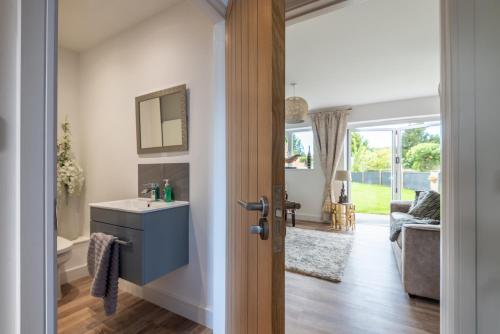 a bathroom with a sink and a mirror at Luxurious 3 bedroom house Shangri la in village of Alfrick with free off road parking for 3 cars in an area of outstanding natural beauty, superb walking,close to Worcester, Malvern showground, theatre, Malvern hills, dogs welcome in Worcester
