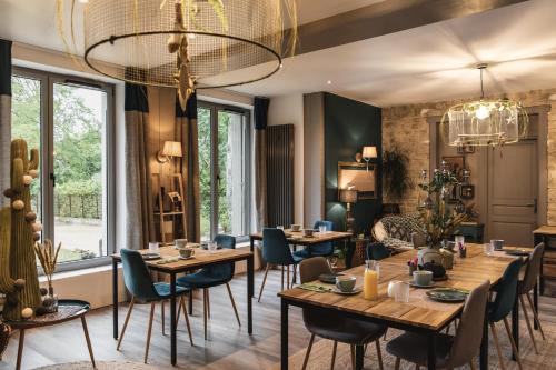 un restaurant avec des tables et des chaises en bois et un lustre dans l'établissement La Bastide de Barbizon, à Barbizon