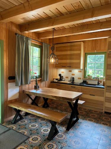 eine Küche mit einem Holztisch und einer Bank in der Unterkunft DOMEK POD TRÓJMORSKIM WIERCHEM in Mittelwalde