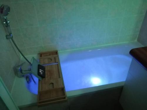 La salle de bains est pourvue d'une baignoire avec une lumière bleue. dans l'établissement Détent'Appart Proche Quais, à Canteleu
