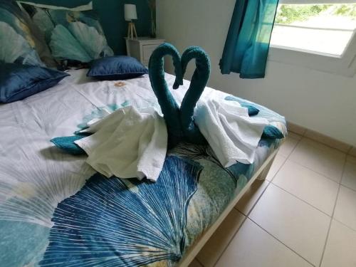 two swans are sitting on a bed with towels at Détent'Appart Proche Quais in Canteleu