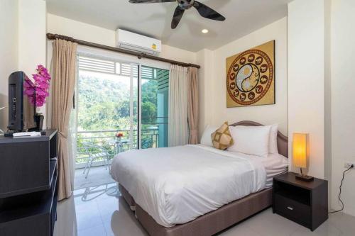 een slaapkamer met een bed, een televisie en een balkon bij Private Rooftop Pool - Penthouse in Phuket