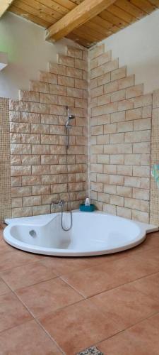 a bath tub in a room with a brick wall at villa Fuga in Avola