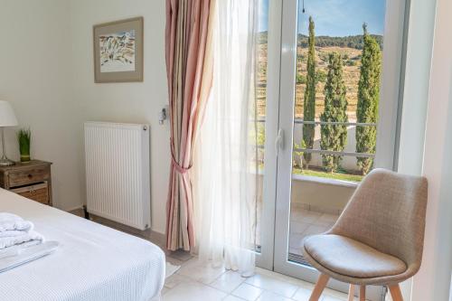 a bed and a chair in a room with a window at Kos Secret Villa with private pool in (( Kermetés ))