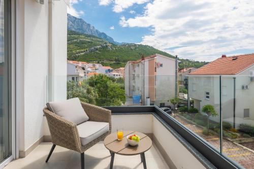 einen Balkon mit einem Stuhl, einem Tisch und Aussicht in der Unterkunft La Suite Apartments 2 in Promajna