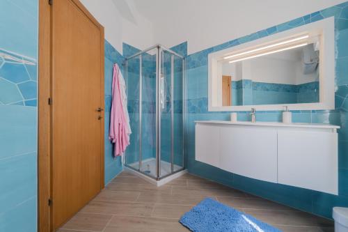 bagno con lavandino bianco e specchio di Angela Suite a Portoferraio