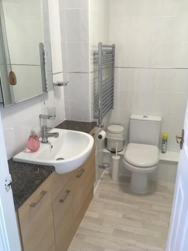 biała łazienka z toaletą i umywalką w obiekcie Two bed flat with stunning views over Fistral Bay! w Newquay