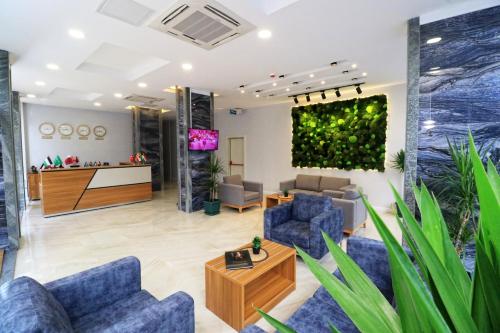 a lobby of a hospital with blue chairs and a tv at ALMIRCAN HOTEL in Trabzon