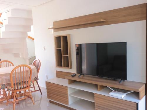 a living room with a flat screen tv on a entertainment center at Refúgio Aconchegante em Canela in Canela