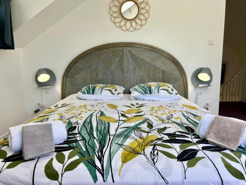 una camera da letto con un grande letto con un copriletto floreale di La Belle Epoque (3*) - Maison avec vue sur mer à Bouillante a Bouillante
