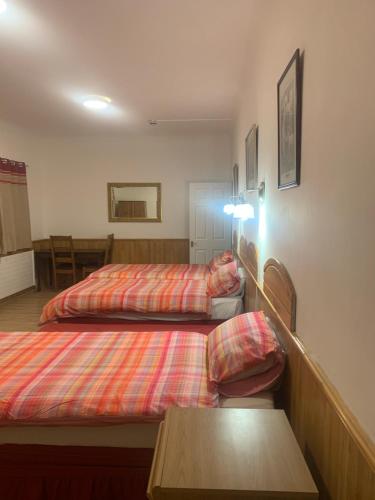 a bedroom with two beds and a table in it at The Dharma Lodge in Enfield
