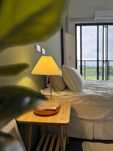 a bedroom with a bed and a table with a lamp at The LINs House in Guiren