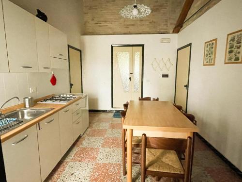 a kitchen with a sink and a table and chairs at Casale Al Fiume in Grottazzolina