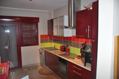 une cuisine avec du carrelage rouge et jaune sur le mur dans l'établissement LE TREPORT 2P 30M2 RDC tout à pied 2mn plage port funiculaire casino, au Tréport
