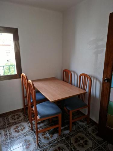 a wooden table and chairs in a room at Apartamento cerca del centro in Vilanova i la Geltrú