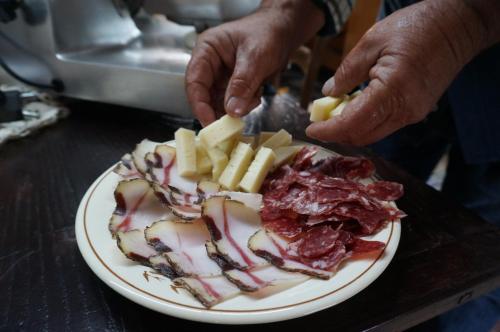 a plate of food with meat and cheese on a table at B&b Ammentos in Magomadas