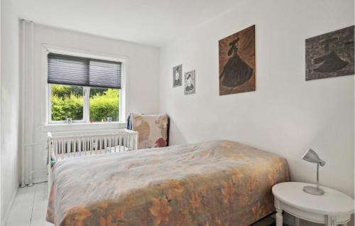 a bedroom with a bed and a table and a window at 1 Bedroom Cozy Apartment In Valby in Copenhagen