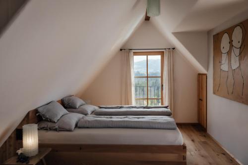 a bed in a room with a window at FRANZL - privates Refugium AmWildbachberg, mit Infinitypool, Weinkeller und Privatsauna in Deutschlandsberg