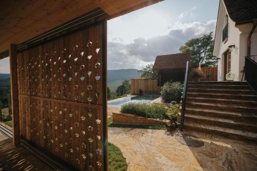 a sliding gate with a view of a house at FRANZL - privates Refugium AmWildbachberg, mit Infinitypool, Weinkeller und Privatsauna in Deutschlandsberg