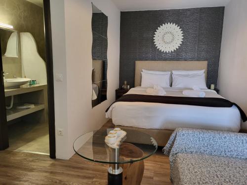 a hotel room with a bed and a glass table at Mykonos Double Luxury Mini Suites-With External Hot spa Adults only in Ano Mera