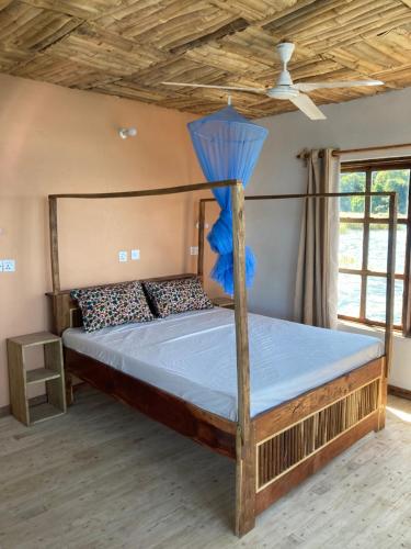 a bedroom with a bed with a blue comforter at Soul Rebel Lodge & Backpackers in Nkhata Bay