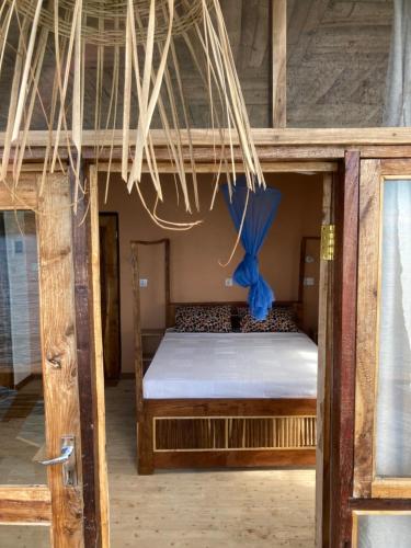 a bedroom with a bunk bed with a blue ribbon at Soul Rebel Lodge & Backpackers in Nkhata Bay