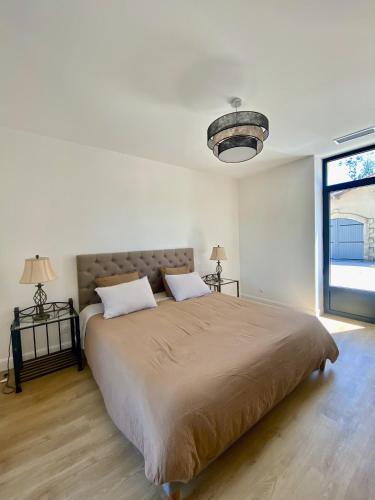 une chambre avec un grand lit avec deux oreillers dans l'établissement L'Eperonnette, cozy house with swimming pool, surrounded by vineyard, near St Emilion, à Vérac