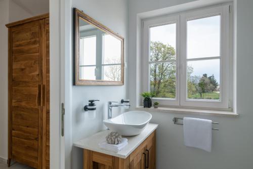 Un baño con lavabo y dos ventanas. en Villa in Kavran, en Kavran