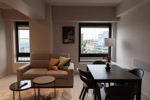 un soggiorno con divano e tavolo di The Dome Aparthotel a Satu Mare