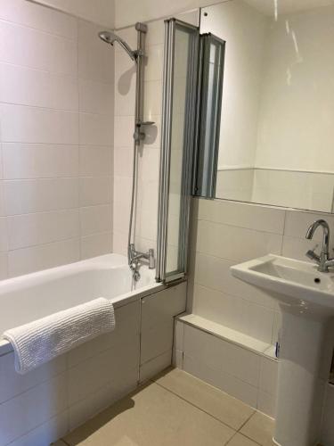 a bathroom with a bath tub and a sink at SeaViewApartment in Swanage