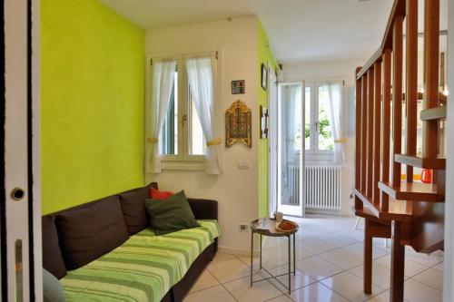 sala de estar con sofá y paredes verdes en BiloBolo, en Bolonia