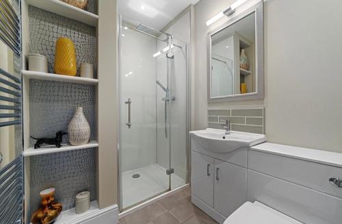 a bathroom with a shower and a sink and a toilet at 119 Flat 2 Northgate st - Stylish one bedroom apartment set within walking distance to town, spacious living space with public car park close by in Bury Saint Edmunds