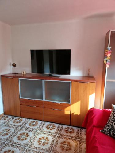 a flat screen tv sitting on top of a wooden entertainment center at Apartamento cerca del centro in Vilanova i la Geltrú