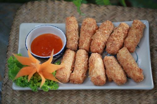 a plate of food with dipping sauce on a table at Vamxang Rustic Home in Can Tho