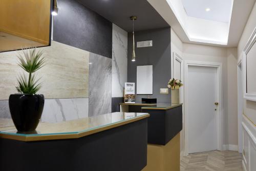 a lobby with a counter with a potted plant at Hotel Roma Vaticano in Rome