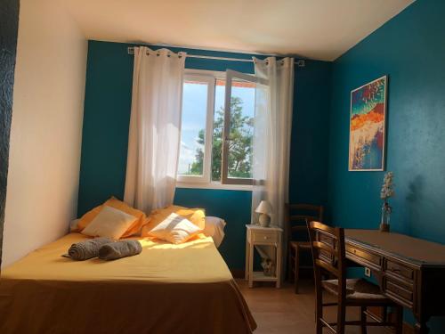 a bedroom with a bed and a desk and a window at Chambres avec piscine in Toulouse