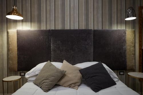 a bed with three pillows on it in a room at Hotel Roma Vaticano in Rome