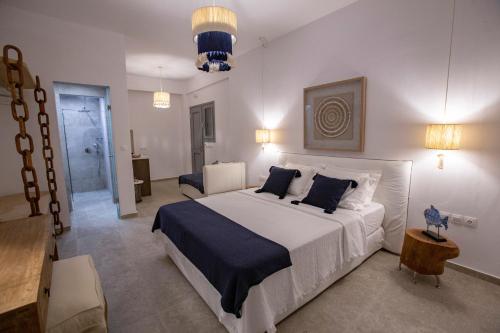 a bedroom with a large white bed with blue pillows at studio lefkes kea in Vourkari