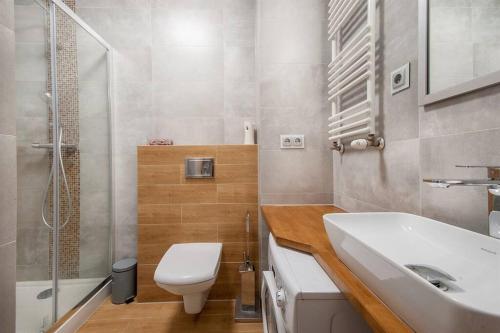 a bathroom with a toilet and a sink and a shower at Funcional Condo- Kraków bezpłatne miejsce w garażu in Krakow