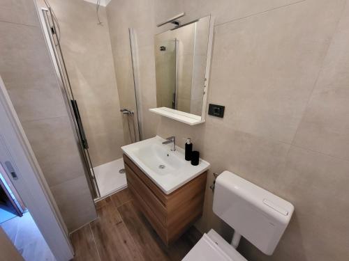 un bagno con lavandino, WC e specchio di MareAmor Studio Rab a Rab