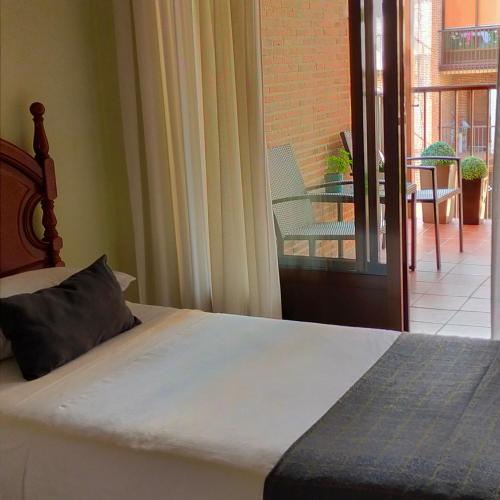 a bedroom with a bed and a balcony at Piso María in Arévalo