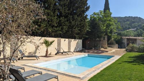 una piscina en un patio con sillas y una valla en Mas des Coccinelles, en Mollans-sur-Ouvèze