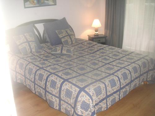 キャヴァレール・シュル・メールにあるLa ptit'Duchのベッドルーム1室(青と白の毛布付きのベッド1台付)