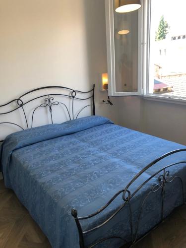 1 dormitorio con 1 cama con edredón azul y ventana en Leonardo luxury apartment, en Florencia